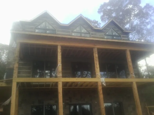 Dormers and porch framing on a large log home under construction — Roof Coating work by our crew in Port Wentworth