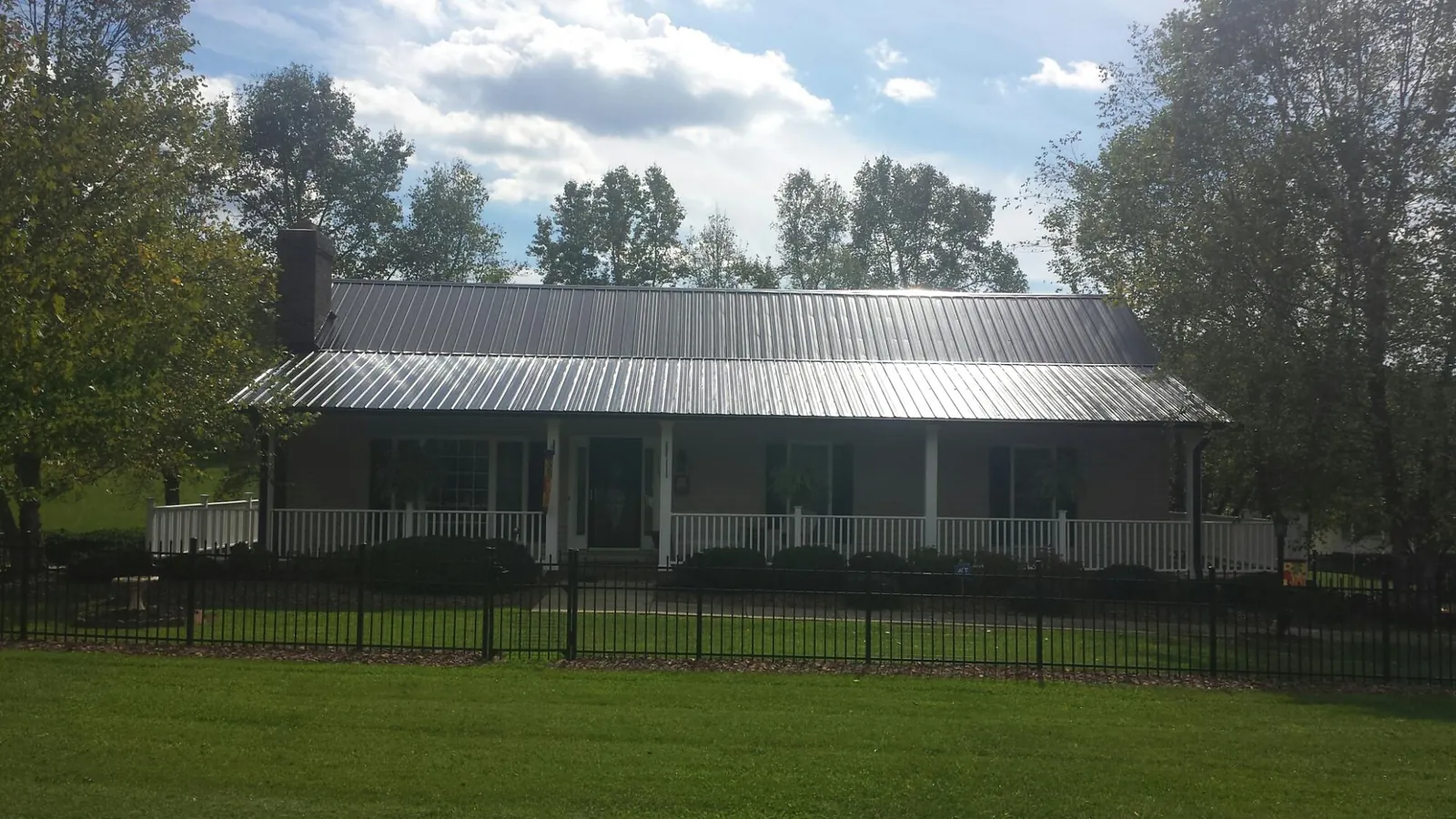 Gray metal roof on a brick ranch with a full width front porch — Gutter Guard Installation work by our crew in Port Wentworth