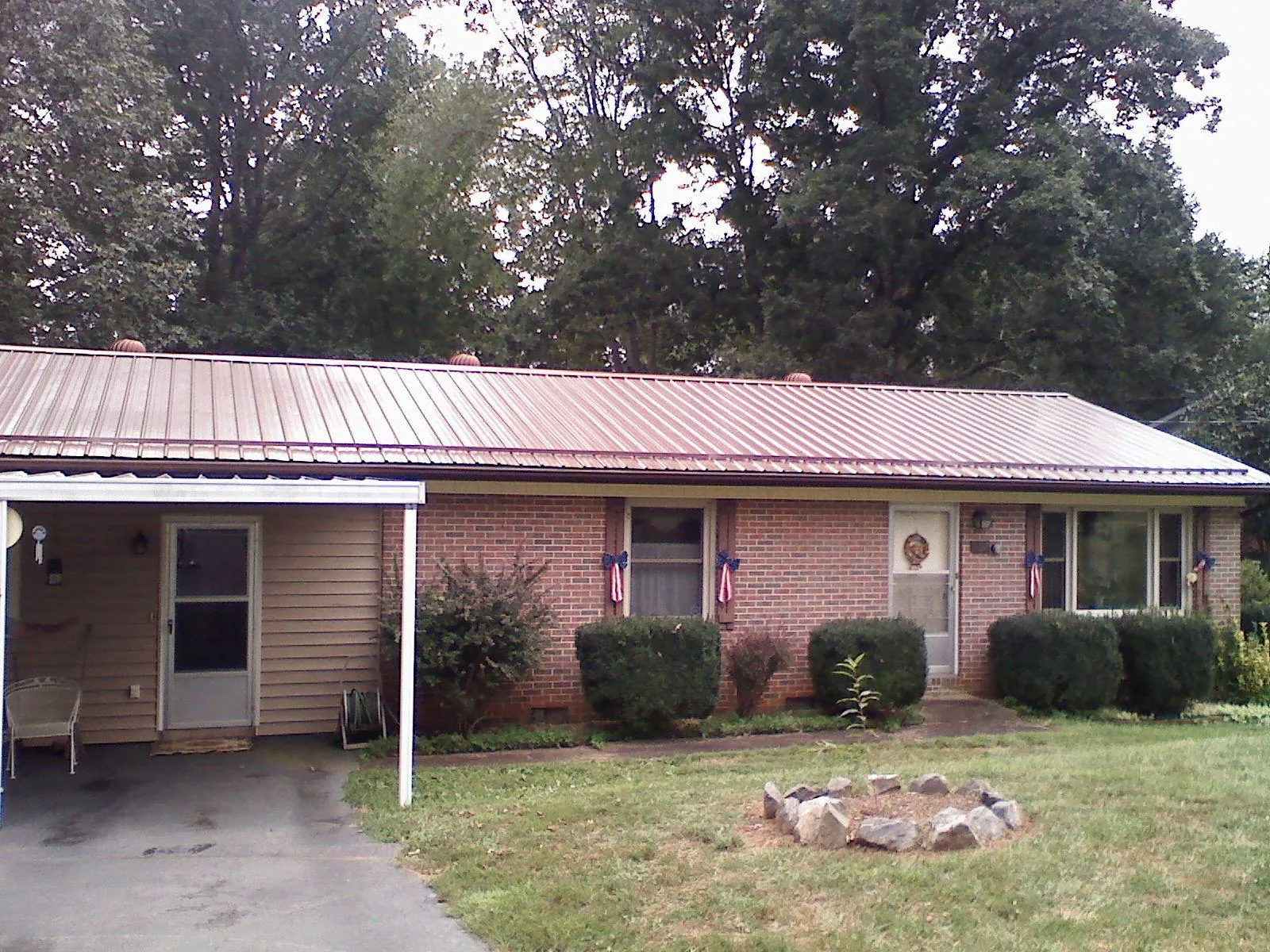 Bronze metal roof and carport on a brick ranch home — Roof Repair work by our crew in Port Wentworth